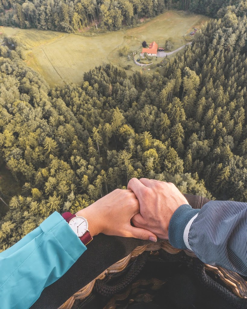 para trzymająca się za ręce z zegarkiem Daniel Wellington podczas lotu balonem w Austrii Styria