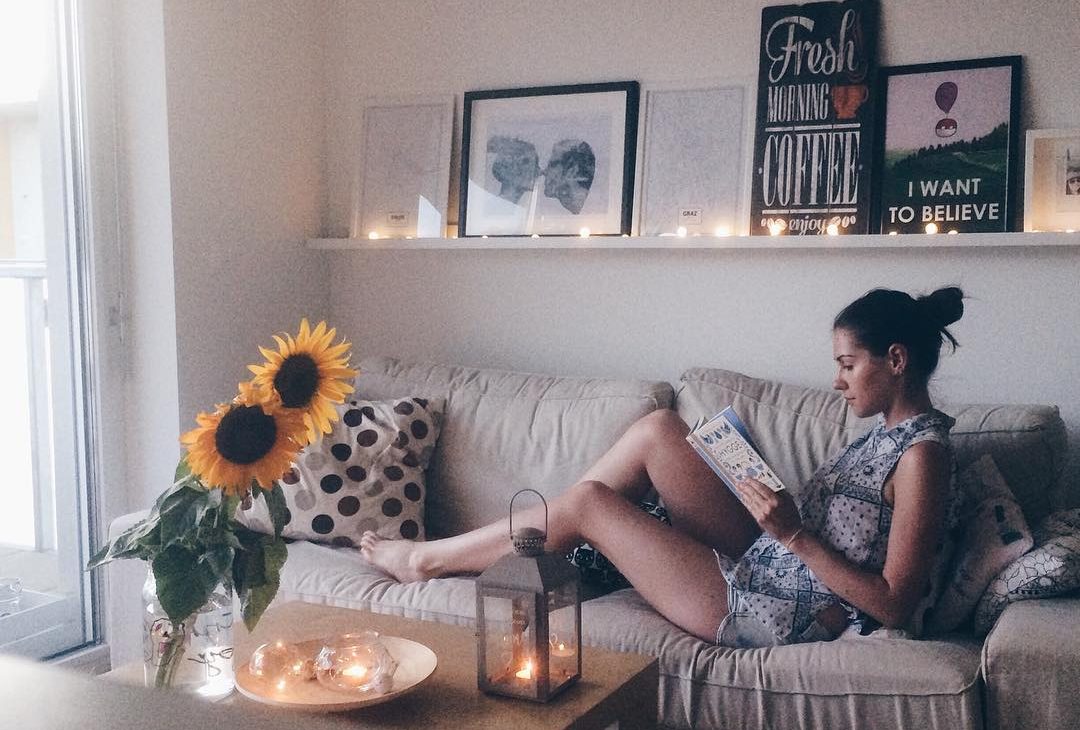 girl reading a book on the couch lifestyle blog