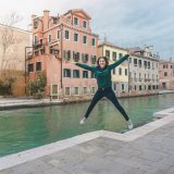 Girl jumping near the canal in Venice.