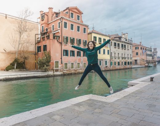 Girl jumping near the canal in Venice.